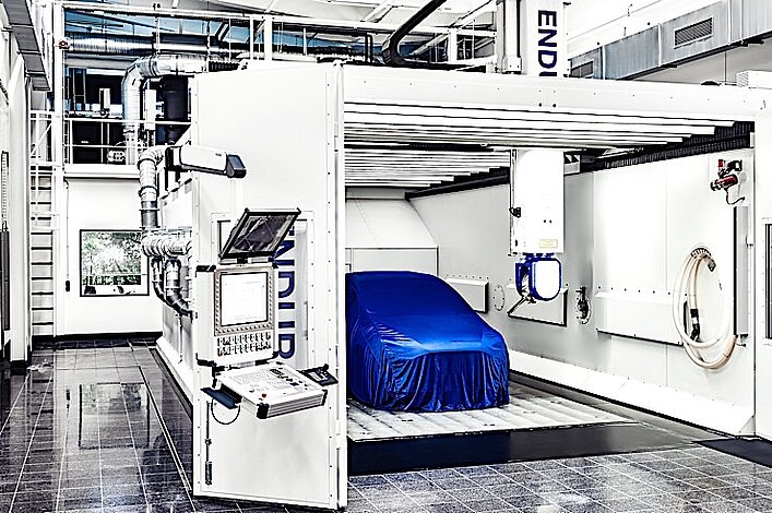 Mit einem blauen Tuch eingehüllte Karosserie steht in der Portalfräsmaschine ENDURA® 600LINEAR.
